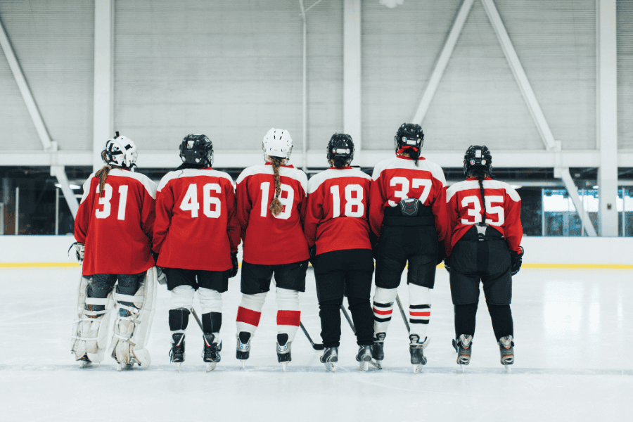 six hockey players with backs facing and numbers on jersey