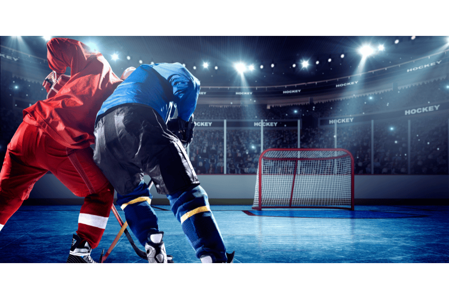 ice hokcey player in blue hip checking player in red jersey